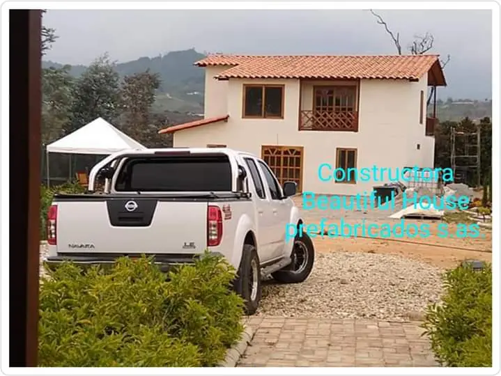 Casa de dos pisos con una camioneta en el frente