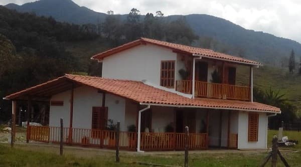 Casa de dos pisos en el campo con césped en la entrada