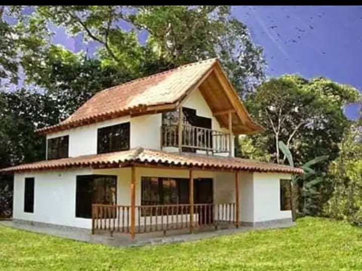 Casa de dos pisos en la montaña con arboles detras